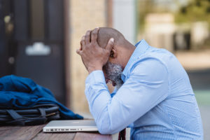 Man grieving over laptop