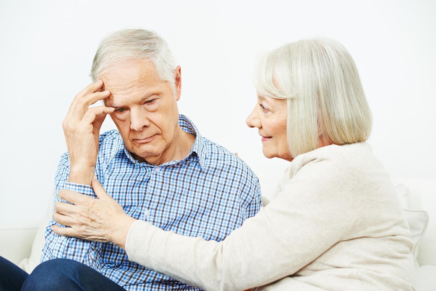 Old woman comforting senior man with depression at home